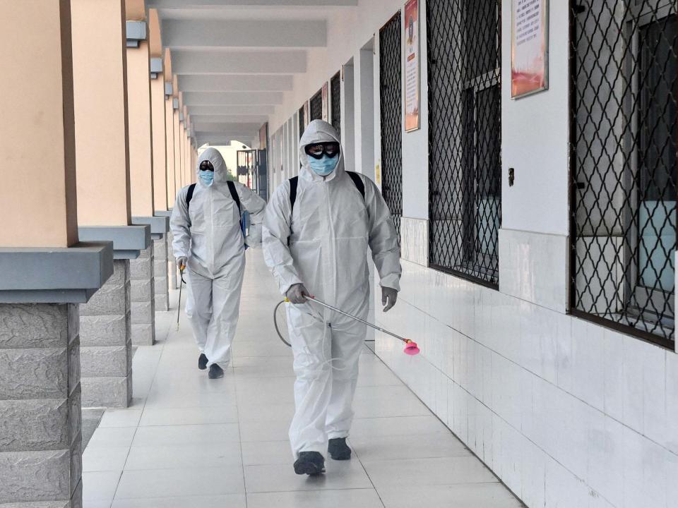 Volunteers spray disinfectant at a school in preparation for students returning following the Covid-19 coronavirus outbreak in Shangqiu in China's central Henan province, 3 April 2020: STR/AFP via Getty Images