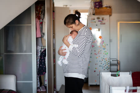 Maria, 31, holds her baby daughter Ioana, who is less than a week old, at their home in London, Britain, February 3, 2019. REUTERS/Alecsandra Dragoi