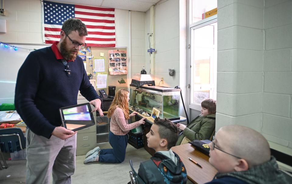 Grand Ledge Hayes Intermediate School teacher Steven Weaver shows students aquarium setups Wednesday, Nov. 29, 2023, during his "Salmon in the Classroom" enrichment class, where students learn the life cycle of salmon. There are more than 30 unique enrichment classes students may choose from based on their personal interests.
