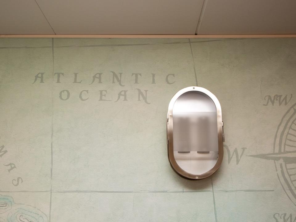 A light mounted on a wall with graphics of the compass, ocean.