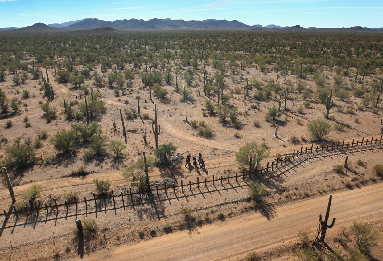 <span class="caption">The political border cuts in two a region rich in biological and cultural diversity.</span> <span class="attribution"><a class="link " href="https://www.gettyimages.com/detail/news-photo/group-of-young-men-walk-along-the-mexican-side-of-the-u-s-news-photo/107497219" rel="nofollow noopener" target="_blank" data-ylk="slk:John Moore/Getty Images News via Getty Images;elm:context_link;itc:0;sec:content-canvas">John Moore/Getty Images News via Getty Images</a></span>