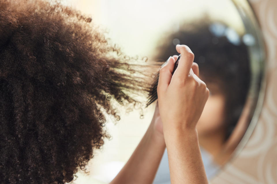 A woman combing her hair in the mirror