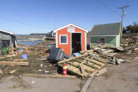 Debris is strewn across a damaged wharf at Stanley Bridge, Prince Edward Island, on Sunday, Sept. 25, 2022. After hammering Atlantic Canada, post-tropical storm Fiona has moved inland in southeastern Quebec, with Environment Canada saying the storm will continue to weaken as it tracks across southeastern Labrador and over the Labrador Sea. (Brian McInnis/The Canadian Press via AP)