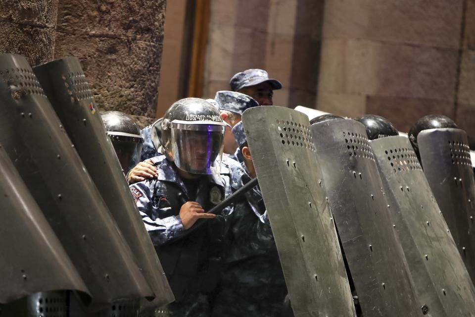 Police officers block an entrance of the government building during a protest against Prime Minister Nikol Pashinyan in Yerevan, Armenia, on Wednesday, Sept. 20, 2023. Protesters gathered in central Yerevan, the capital of Armenia, blocking streets and demanding that authorities defend Armenians in Nagorno-Karabakh. (Vahram Baghdasaryan/Photolure via AP)