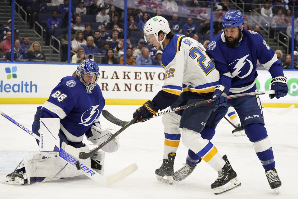 Tampa Bay Lightning goaltender Andrei Vasilevskiy (88) makes a stick save on a shot by St. Louis Blues center Logan Brown (22) during the first period of an NHL hockey game Thursday, Dec. 2, 2021, in Tampa, Fla. Looking on for the Lightning is defenseman Zach Bogosian (24). (AP Photo/Chris O'Meara)