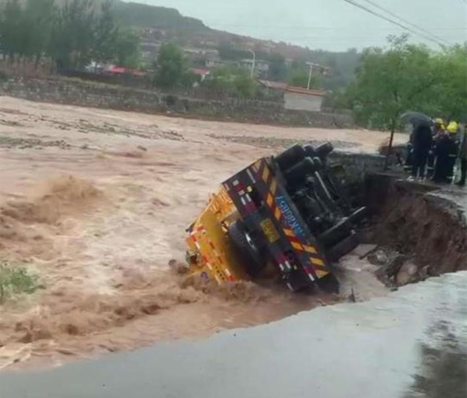 ▲山西連日暴雨釀災，6日有吊車沿著河壩行駛時，突然遇上河壩坍塌，吊車墜入河床後側翻。（圖／翻攝自中新網）