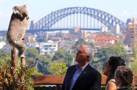 U.S. Vice President Mike Pence looks at a koala with his daughters Charlotte and Audrey and a keeper during a visit to Taronga Zoo in Sydney, Australia, April 23, 2017. REUTERS/Jason Reed