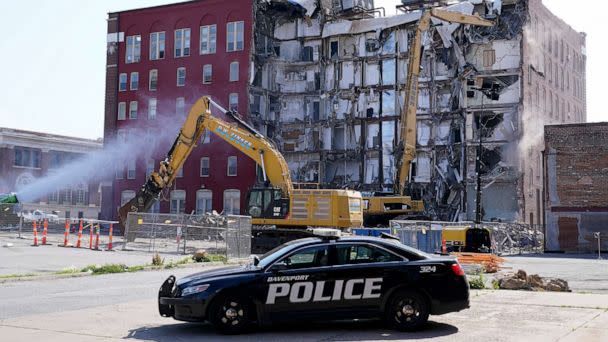 PHOTO: A police officer watches the start of the demolition of the partially collapsed apartment building, June 12, 2023, in Davenport, Iowa. (Charlie Neibergall/AP)