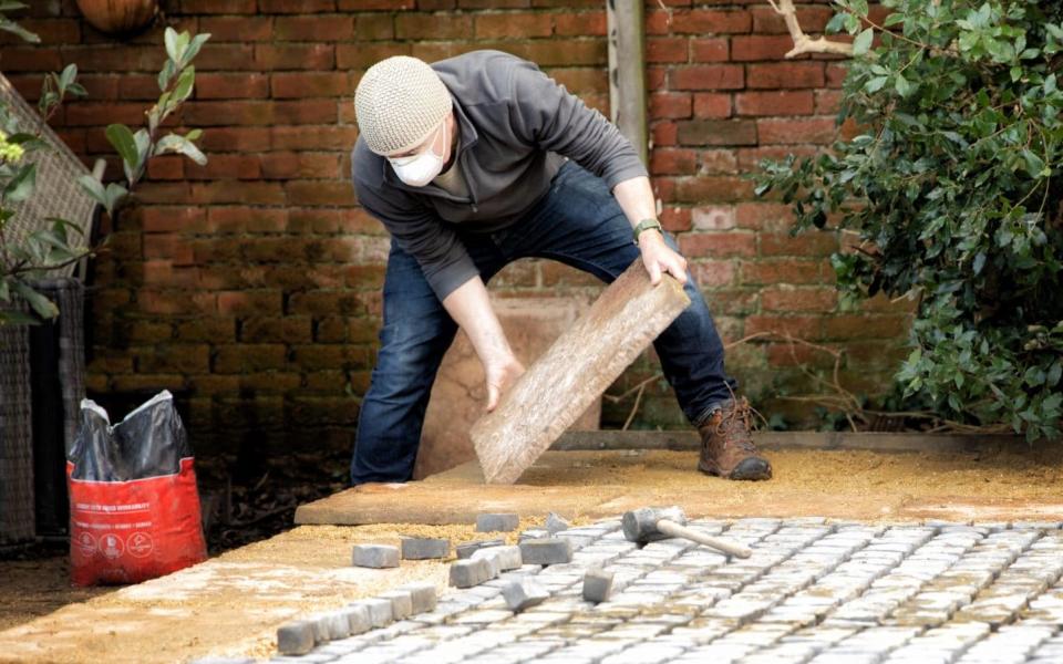 Man laying patio slabs and cobbles