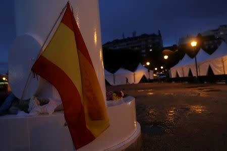 A Spanish flag and bouquets of flowers are laid out on the base of a big flagpole at Plaza de Colon (Columbus Square) in Madrid, Spain, October 18, 2017. REUTERS/Susana Vera