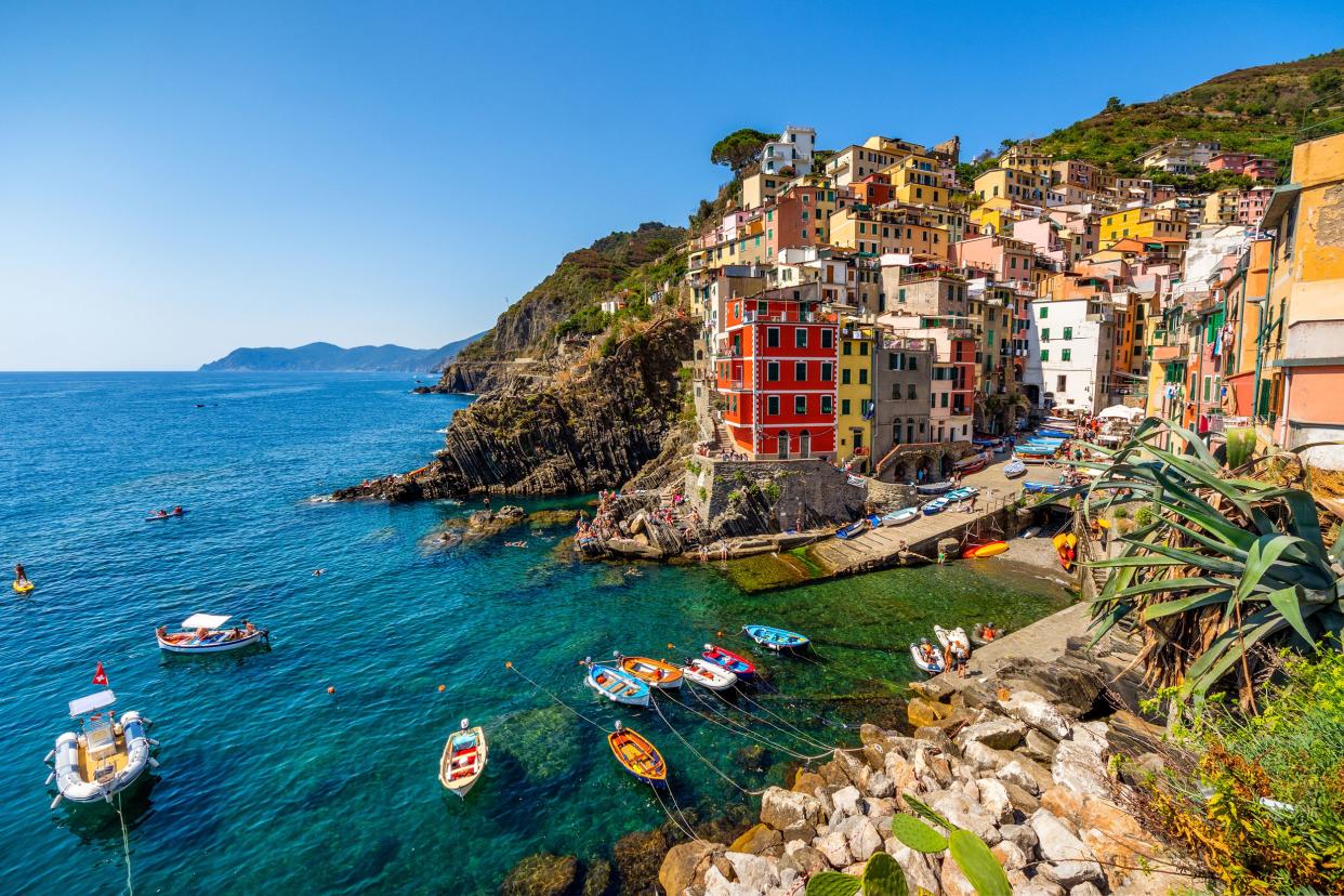 Wide angle view of the Village Riomaggiore in Cinque Terre National Park, Liguria Italy on a sunny summer day with small boats in the sea