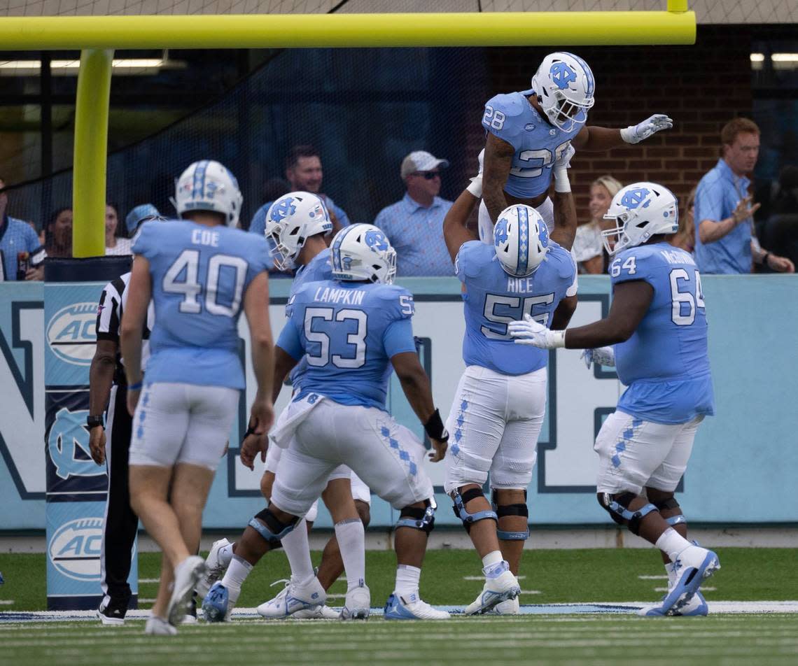 North Carolina offensive lineman Zach Rice (55) hoists running back Omarion Hampton (28) after a 68-yard romp for a touchdown to give the Tar Heels a 7-3 lead in the second quarter on Saturday September 9, 2023 at Kenan Stadium in Chapel Hill, N.C.