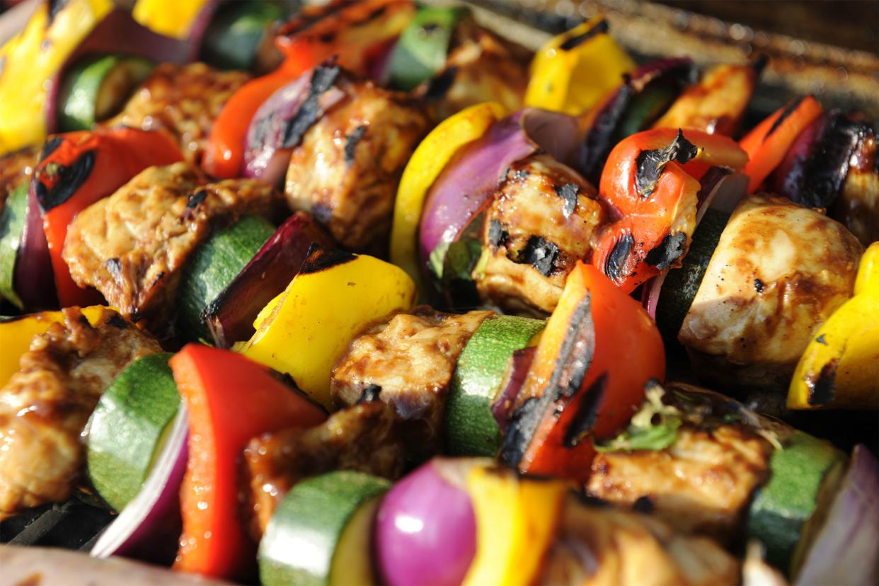 Four skewers of chicken-and-summer-squash kebabs on a grill plate