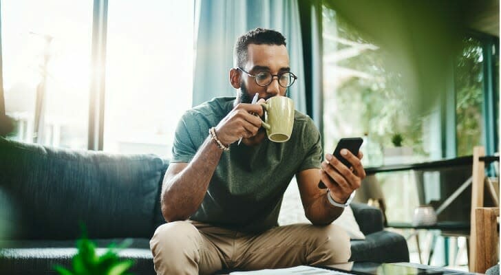 A man checks his bond portfolio on his phone. 