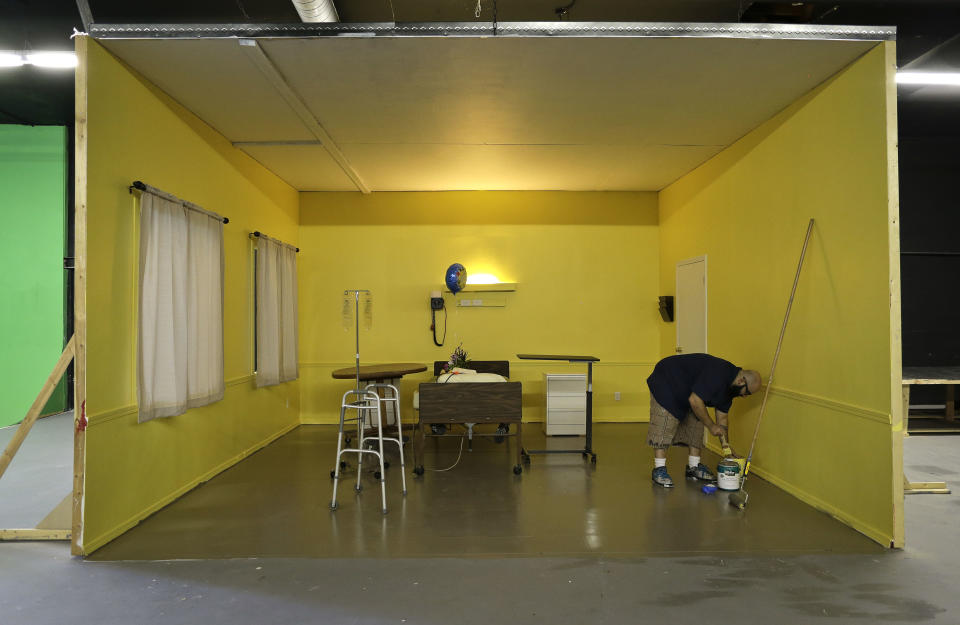 Studio owner and porn film director Lee Roy Myers prepares paint while working on a hospital room set at his studio, Mission Control Studios, Wednesday, Jan. 15, 2014, in Las Vegas. With increasing costs of doing business and a Los Angeles law requiring male actors to wear condoms, Myers moved his studio to Las Vegas last Spring and is part of the new boom in X-rated production in Sin City. (AP Photo/Julie Jacobson)