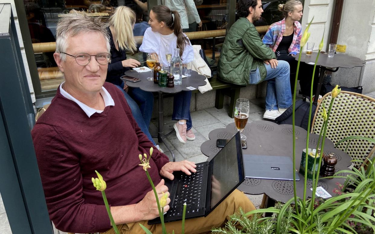 State epidemiologist Anders Tegnell, Public Health Agency of Sweden, enjoying a beer while working on his laptop at an outdoor restaurant in Stockholm -  Peter Kadhammar/Aftonbladet