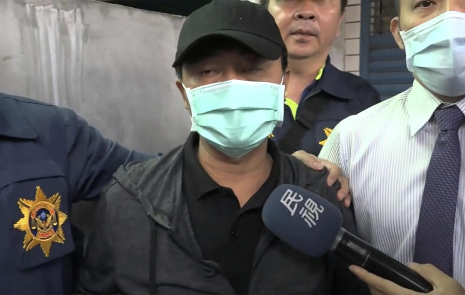 In this image taken from video, Lee Yi-hsiang, the driver of the truck that caused the train accident on Saturday, offers a public apology as he is led by police Sunday, April 4, 2021, in Hualien, Taiwan. Lee's truck slid into the path of an oncoming train, causing Taiwan's worst railway accident in decades that which killed dozens of people, and injuring hundreds more. (EBC via AP)