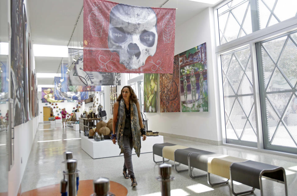 Fashion designer Donna Karan walks through the art gallery during her visit to Little Haiti at the Discover Haiti Exhibition in Miami, Friday, May 17, 2013. Karan is among the designers and celebrities who have advocated for Haitian artisans since a catastrophic earthquake shook the Caribbean country in 2010. (AP Photo/Alan Diaz)