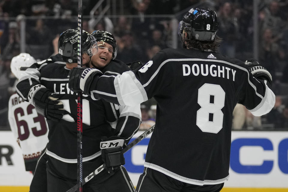 Los Angeles Kings center Blake Lizotte, center, celebrates with center Trevor Lewis (61) and defenseman Drew Doughty (8) after scoring during the second period of an NHL hockey game against the Arizona Coyotes Tuesday, Oct. 24, 2023, in Los Angeles. (AP Photo/Ashley Landis)