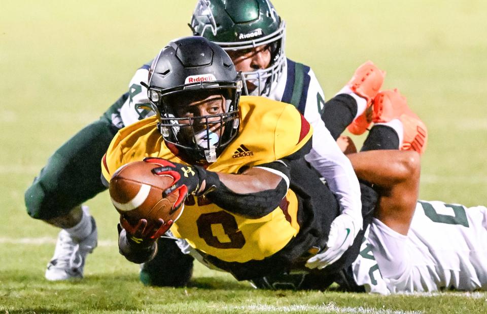 Tulare Union's Tieler Peterson reaches for extra yards while in the grip of El Diamante's Joseph Pena, left, and Jayden Lopez in a non-league high school football Thursday, August 24, 2023.