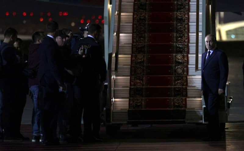 Russian President Vladimir Putin (R) waits for the prisoners released after the exchange agreement at Vnukovo International Airport in Moscow. -/KREMLIN/dpa