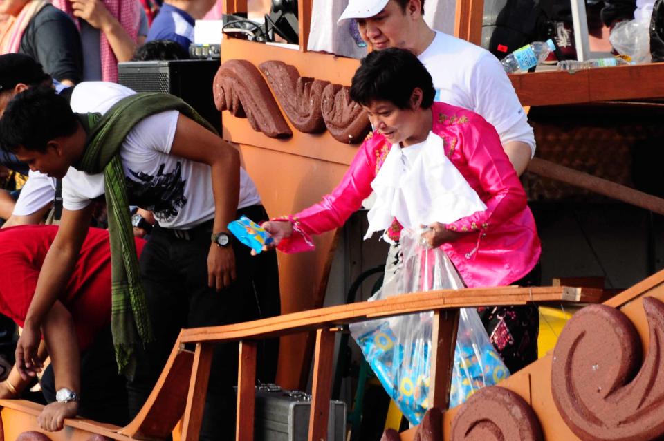 Award winning actress Nora Aunor gives out freebies to the crowd as the float of the MMFF 2012 entry "Thy Womb" makes its way at the 2012 Metro Manila Film Festival Parade of Stars on 23 December 2012. (Angela Galia/NPPA Images)