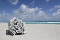 FILE - In this March 19, 2020 file photo, beach chairs sit on on an empty beach in Miami Beach, Fla. Reaction to the coronavirus, change came to the United States during the third week of March in 2020. It did not come immediately, though it came quite quickly. There was no explosion, no invasion other than a microscopic one that nobody could see. (AP Photo/Lynne Sladky, File)