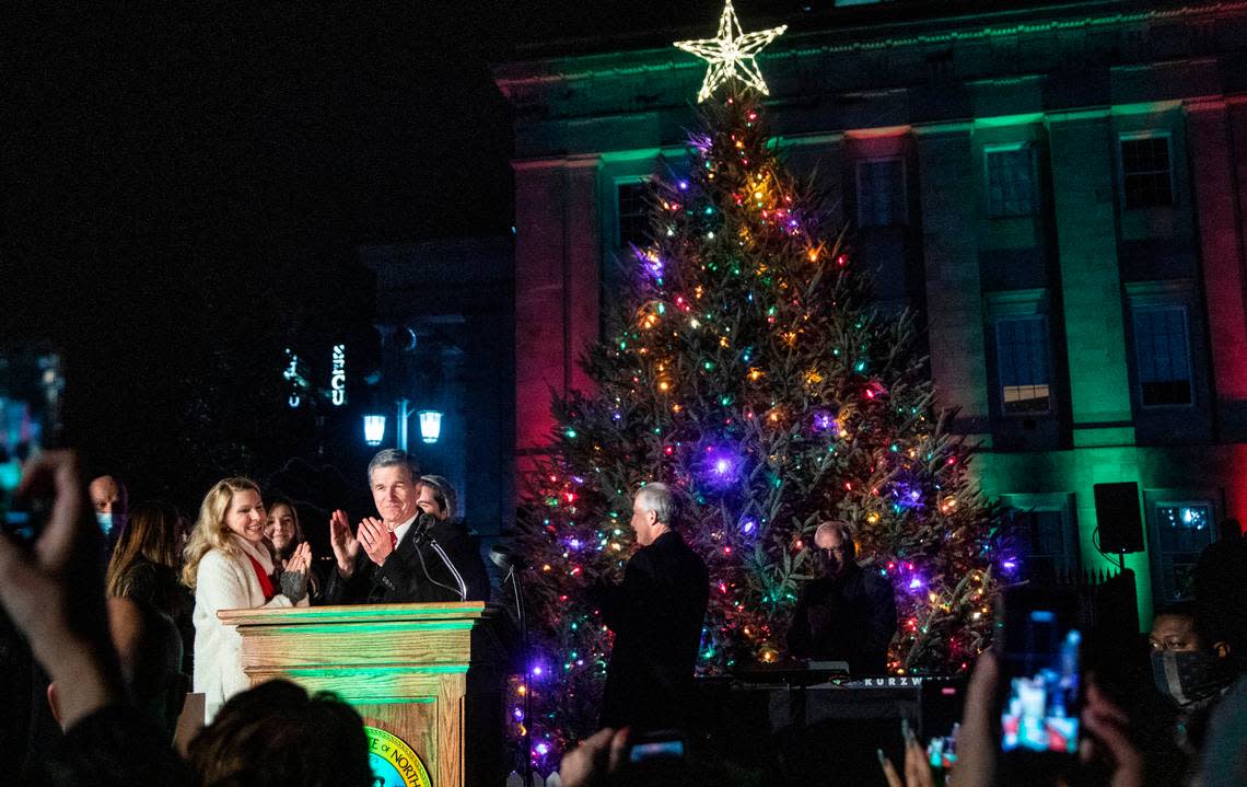 Gov. Roy Cooper and North Carolina First Lady Kristin Cooper react after the lighting of the State Capitol tree during a ceremony at North Carolina State Capitol Thursday, Dec. 9, 2021.