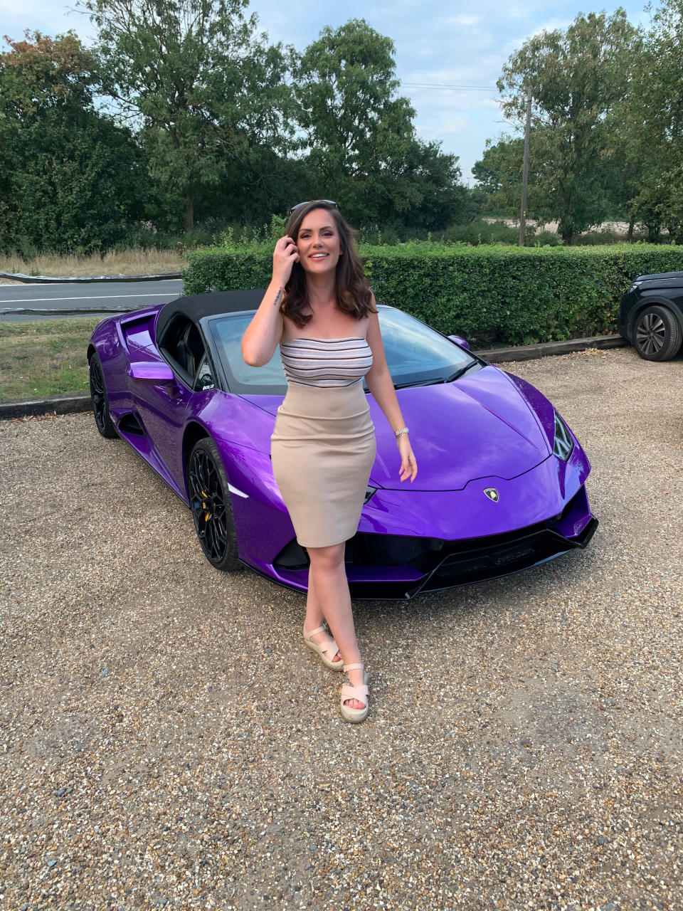 OnlyFans star Charlotte Rose next to a purple Lamborghini