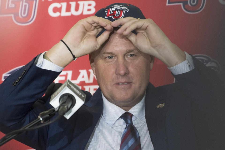 Liberty University’s new NCAA college football head coach Hugh Freeze puts on his LU cap during a press conference Friday Dec. 7, 2018, in Lynchburg, Va. (AP)