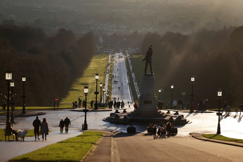 People walk through the grounds of the Stormont Parliament buildings in Belfast