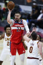 Washington Wizards' Alex Len (27) passes the ball away from Cleveland Cavaliers' Kevin Love (0) and Collin Sexton (2) during the second half of an NBA basketball game, Friday, April 30, 2021, in Cleveland. (AP Photo/Ron Schwane)