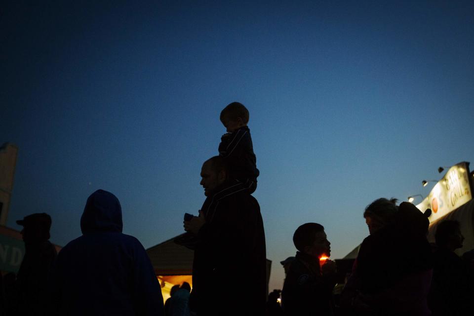 A child sits on his father's shoulders as they take part in a "Light The Shore" event on the one year anniversary of the landfall of Hurricane Sandy in Seaside Heights