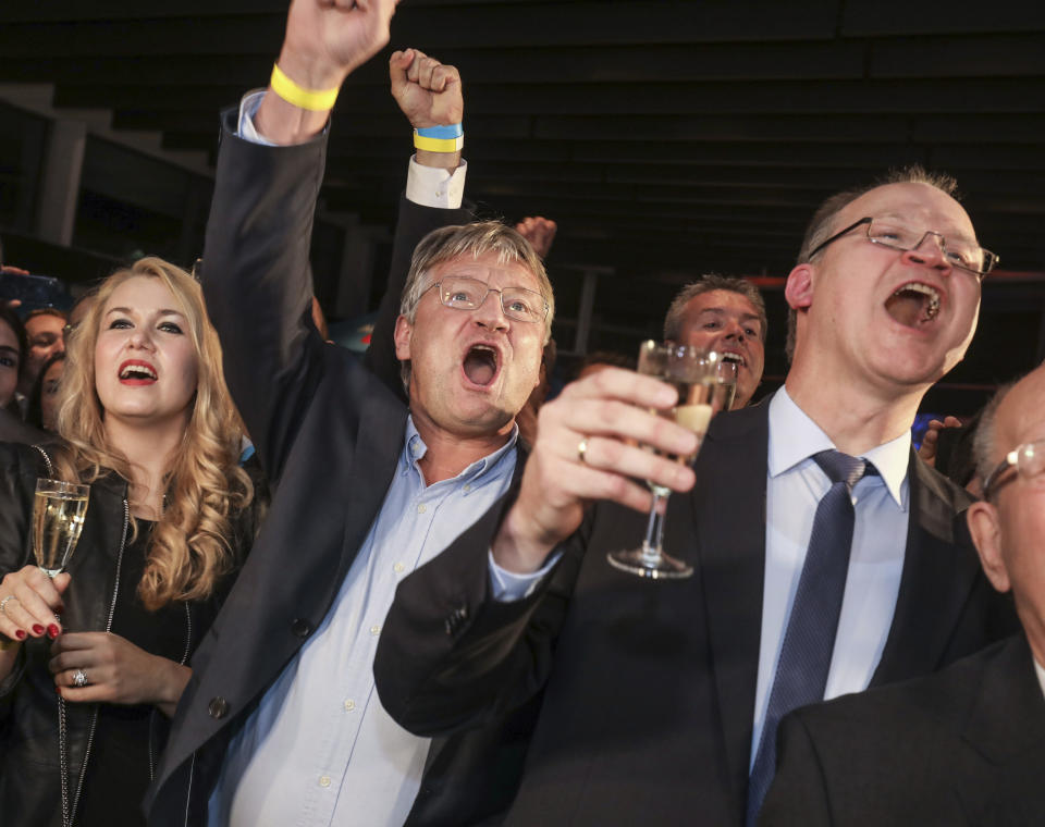 Natalia Meuthen, wife of AfD co-chairman Joerg Meuthen, and AfD state chairman Klaus Herrmann, from left, celebrate after the state election in the German state of Hesse in Wiesbaden, western Germany, Sunday, Oct. 28, 2018. Exit polls show Chancellor Angela Merkel’s party leading with a significant drop in support for both her conservatives and their center-left partners in the national government. The nationalist Alternative for Germany, AfD, were elected into the parliament for the first time. (Frank Rumpenhorst/dpa via AP)