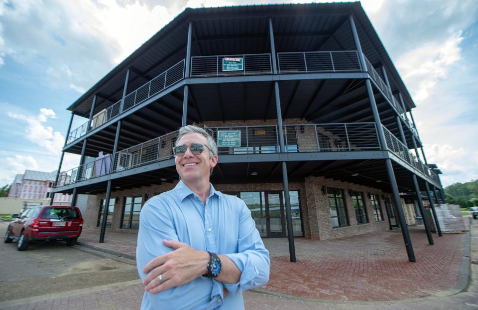 Developer Todd Everette says, Tuesday, May 16, 2023, that the new multi-purpose building, background, in the Lost Rabbit town center in Madison, Miss., includes a general store and snack bar on the bottom floor with six high-end condominiums on the upper floors that overlook the marina. The building is expected to open in the early part of June with the condominiums opening shortly thereafter. An adjacent craft cocktail bar is slated to open this summer. The store and bar are open to the public.