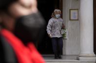 A woman wearing a face mask to curb the spread of coronavirus, exits from a Greek Orthodox church in Athens, Greece, Monday, Jan. 17, 2022. Greece has imposed a vaccination mandate for people over age 60, as coverage remains below the European Union average and while a recent spike in infections has sustained pressure on hospitals. (AP Photo/Thanassis Stavrakis)