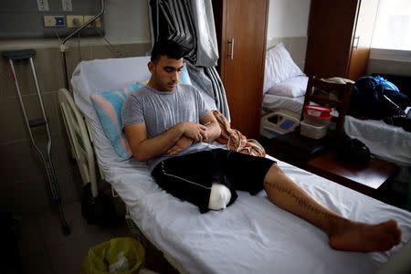 Palestinian cyclist Alaa Al-Daly, 21, who lost his leg by a bullet fired by Israeli troops, prays at a hospital in Gaza City, April 18, 2018. REUTERS/Suhaib Salem