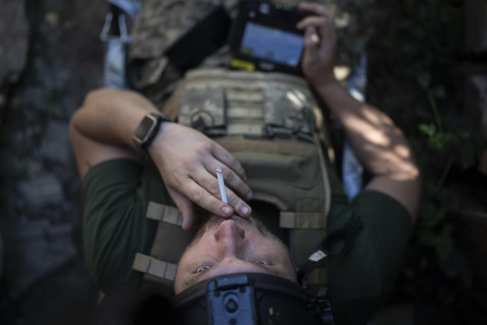 A Ukrainian soldier smokes a cigarette while operating an intelligence drone in the Luhansk region, Ukraine, Saturday, Aug. 19, 2023. Moscow’s army is staging a ferocious push in northeast Ukraine designed to distract Ukrainian forces from their counteroffensive and minimize the number of troops Kyiv is able to send to more important battles in the south. (AP Photo/Bram Janssen)