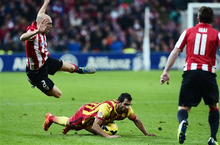 Athletic Bilbao's Gaizka Toquero falls over Barcelona's Martin Montoya during their Spanish first division soccer match at San Mames stadium in Bilbao December 1, 2013. REUTERS/Vincent West