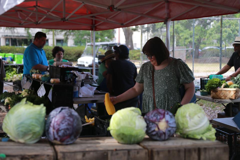 Shoppers browse the produce at the Forsyth Park Farmers Market.