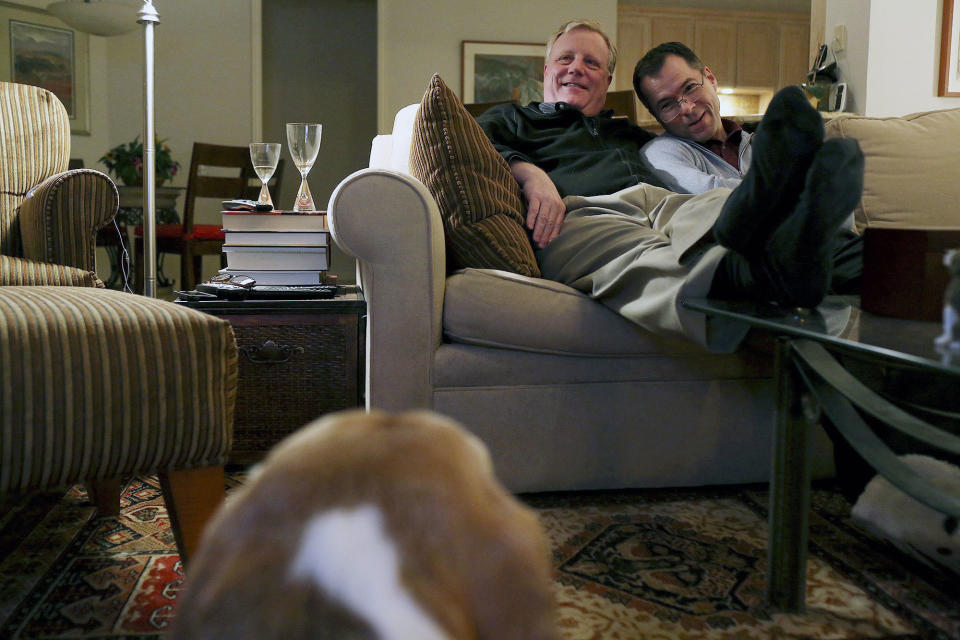 In this Feb. 7, 2014 photo, Mark Phariss, left, and Victor Holmes watch a movie at their home in Plano, Texas A federal judge is expected to hear arguments Wednesday, Feb. 12, 2014, in a lawsuit brought by two homosexual couples who say the Texas Constitution’s ban on gay marriage is unconstitutional because it denies them the right to be treated like everyone else. (AP Photo/The San Antonio Express-News, Lisa Krantz) RUMBO DE SAN ANTONIO OUT; NO SALES; MAGS OUT