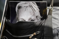 A poster of Julian Assange is seen inside a handbag of a protestor as supporters stage a demonstration outside the High Court in London, Wednesday, Oct. 27, 2021. The U.S. government is scheduled to ask Britain's High Court to overturn a judge's decision that WikiLeaks founder Julian Assange should not be sent to the United States to face espionage charges. A lower court judge refused extradition in January on health grounds, saying Assange was likely to kill himself if held under harsh U.S. prison conditions. (AP Photo/Frank Augstein)