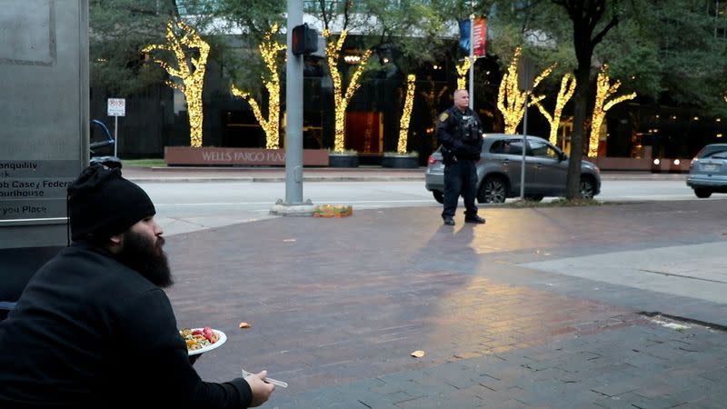 A man eats his food as volunteers who feed the homeless are being ticketed by the police in Houston, TX