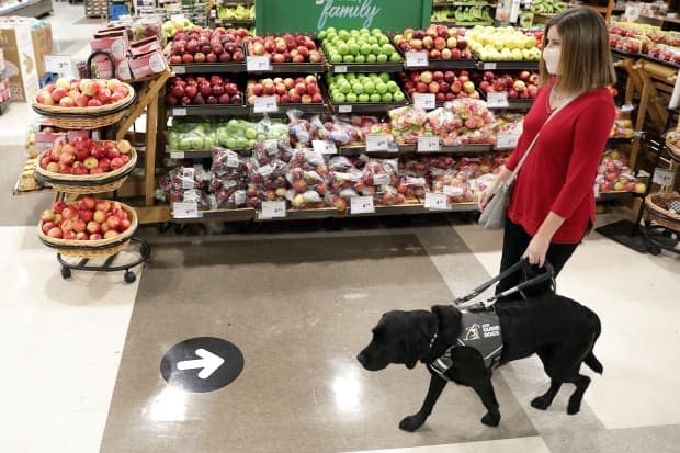 Shelley Adams, with Rookie, showing that guide dogs can also misread directional signs in a retail shop.