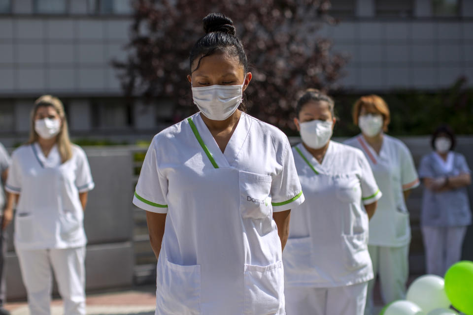 Workers of a nursing home "DomusVi Arturo Soria" hold a minute of silence in support of the social and health sector and its workers in Madrid, Spain, Tuesday, Sept. 15, 2020. After ending a strict lockdown in June having brought under control the virus transmission, Spain is now the European country where a second wave of the contagion is being more noticed. (AP Photo/Manu Fernandez)