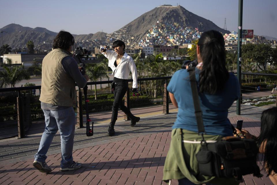 Peruvian singer Lenin Tamayo strikes a pose during the recording of a music video in Lima's downtown, Peru, Thursday, Aug. 3, 2023. With his fusion of K-pop and Andean culture, the 23-year-old composer is known as the inventor of Quechua pop or Q-pop, writing songs in Spanish and Quechua. (AP Photo/Martin Mejia)