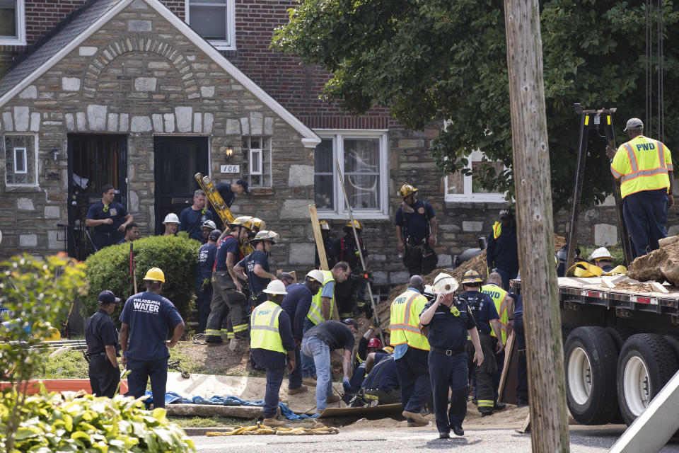 Rescuers work to locate and free a contractor who became trapped when a trench collapsed at a work site in a residential area of Philadelphia, Thursday, Aug. 16, 2018. (AP Photo/Matt Rourke)