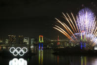 Fireworks explode near the illuminated Olympic rings during a ceremony held to celebrate the 6-months-to-go milestone for the Tokyo 2020 Olympics Friday, Jan. 24, 2020, in the Odaiba district of Tokyo. (AP Photo/Jae C. Hong)