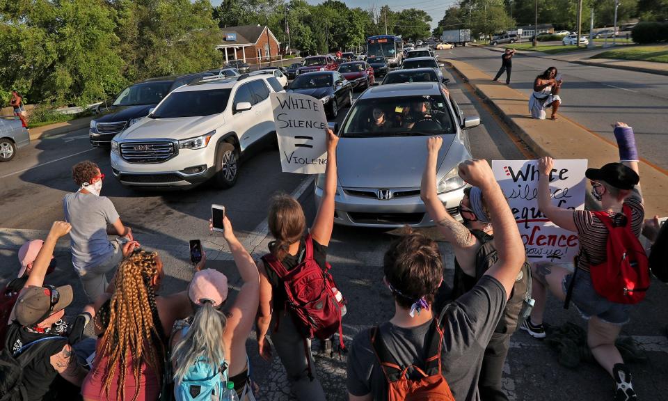 Protesters kneel in the intersection as they march along 38th Street, stopping at and blocking the intersections, after the "Chalking in Remembrance of Dreasjon Reed," Friday, June 5, 2020, at the IMPD NW District Headquarters. Cars waited for the intersection to clear, some people getting out to show support.