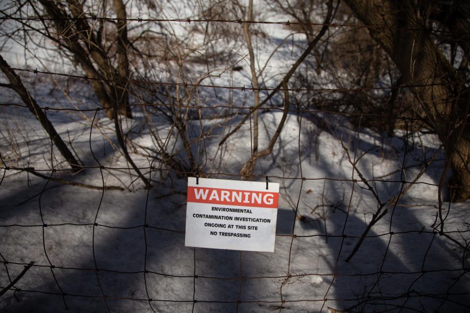 A sign posted on a fence around the former House Street landfill in Belmont warning of environmental contamination research is seen on Monday, March 11, 2019, where Wolverine Worldwide dumped its PFAS-containing waste for decades.